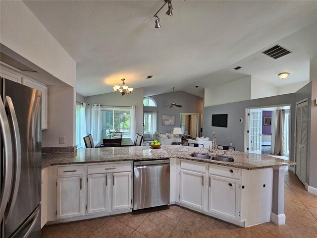 1022 Bartlett Ct, Oviedo, FL 32765 - kitchen featuring stainless steel appliances, lofted ceiling, white cabinets, light tile patterned flooring, and light stone counters