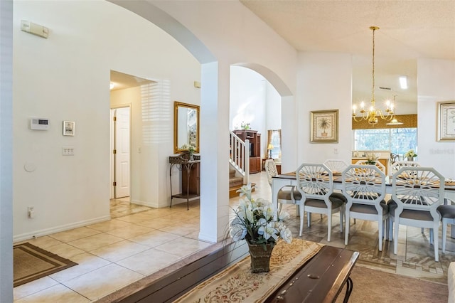 tiled dining room with a textured ceiling and an inviting chandelier