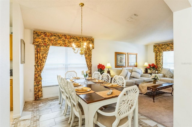 dining space featuring light carpet and a chandelier