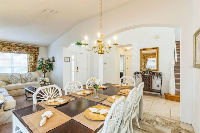 tiled dining space featuring a chandelier and vaulted ceiling