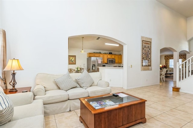 living room with light tile patterned floors and a high ceiling