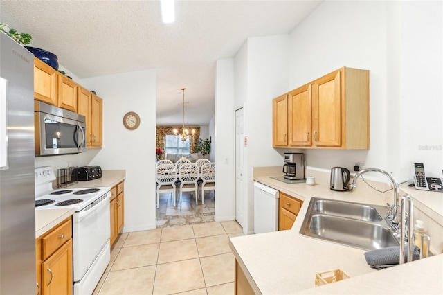 kitchen with stainless steel appliances, sink, pendant lighting, light tile patterned floors, and a notable chandelier