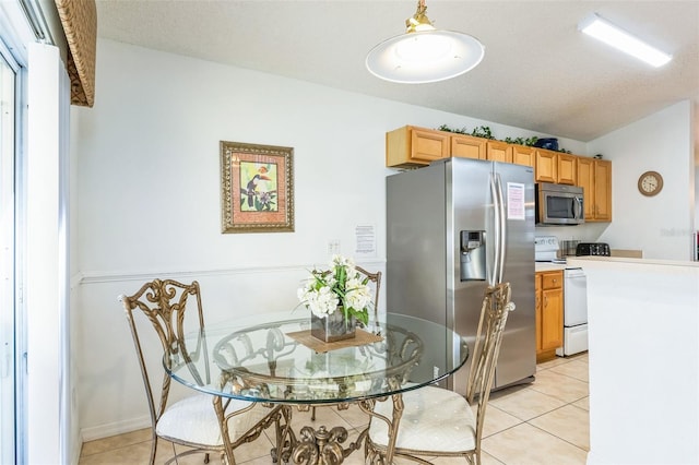 dining area featuring light tile patterned floors and a textured ceiling