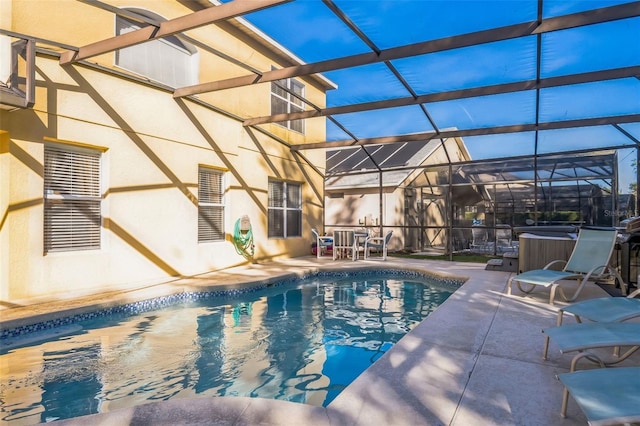 view of swimming pool featuring glass enclosure, a patio, and a hot tub