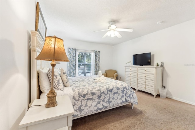 carpeted bedroom featuring ceiling fan and a textured ceiling