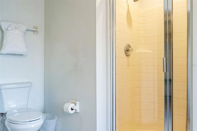 bathroom with a shower with door and toilet