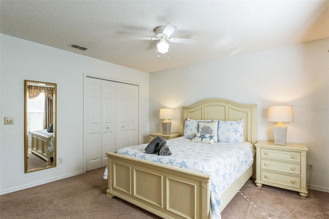 bedroom featuring carpet flooring, a textured ceiling, a closet, and ceiling fan