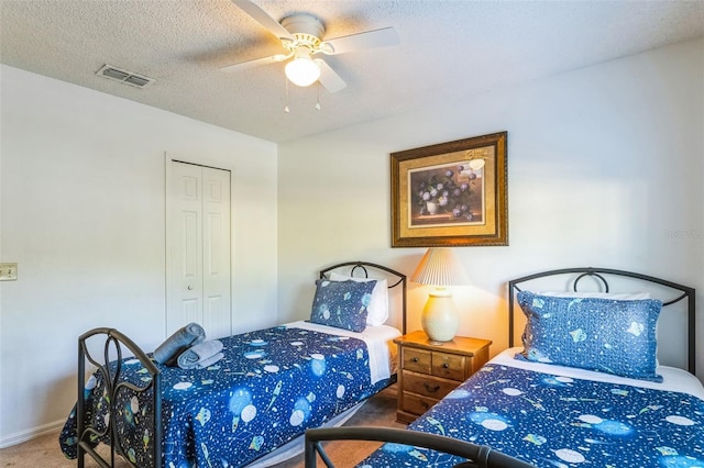 carpeted bedroom featuring ceiling fan, a textured ceiling, and a closet