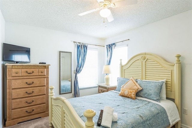 carpeted bedroom with a textured ceiling and ceiling fan