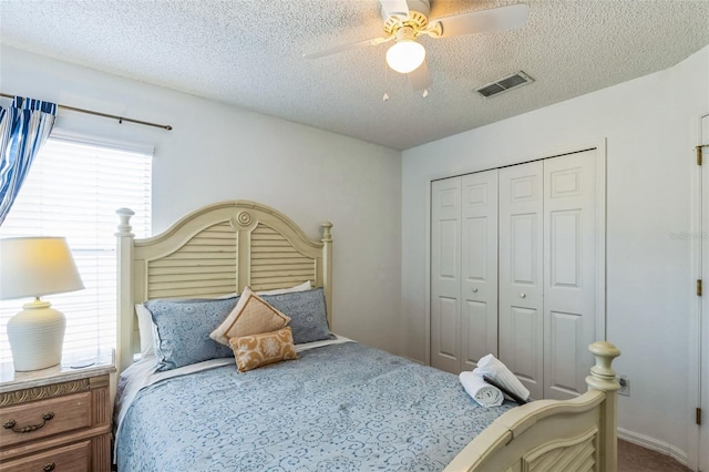 bedroom with ceiling fan, a closet, and a textured ceiling