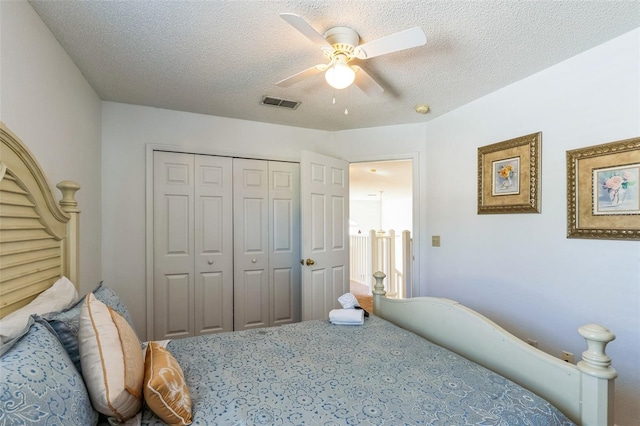 bedroom featuring ceiling fan, a closet, carpet floors, and a textured ceiling