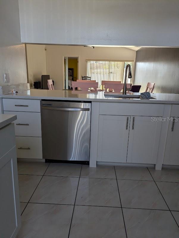 kitchen featuring white cabinets, stainless steel dishwasher, and sink