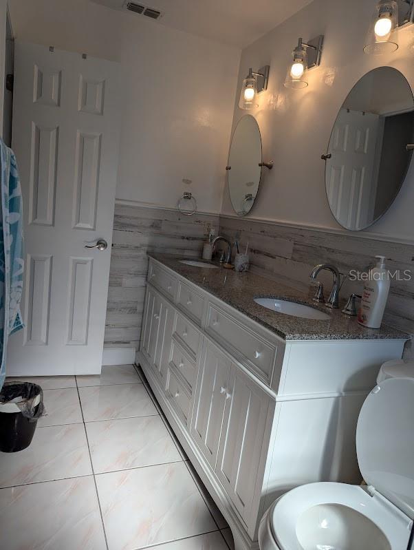 bathroom featuring tile patterned flooring, vanity, and toilet