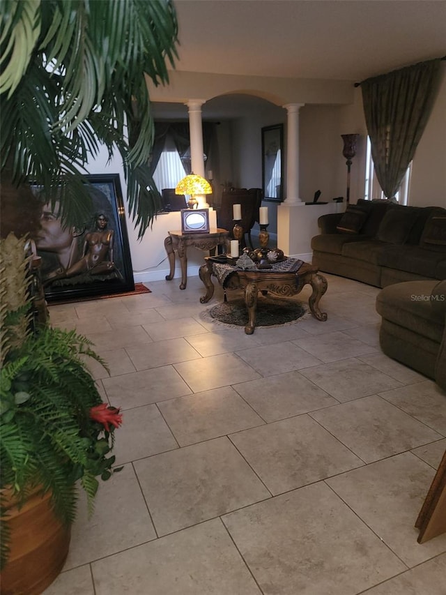 living room featuring ornate columns and light tile patterned floors