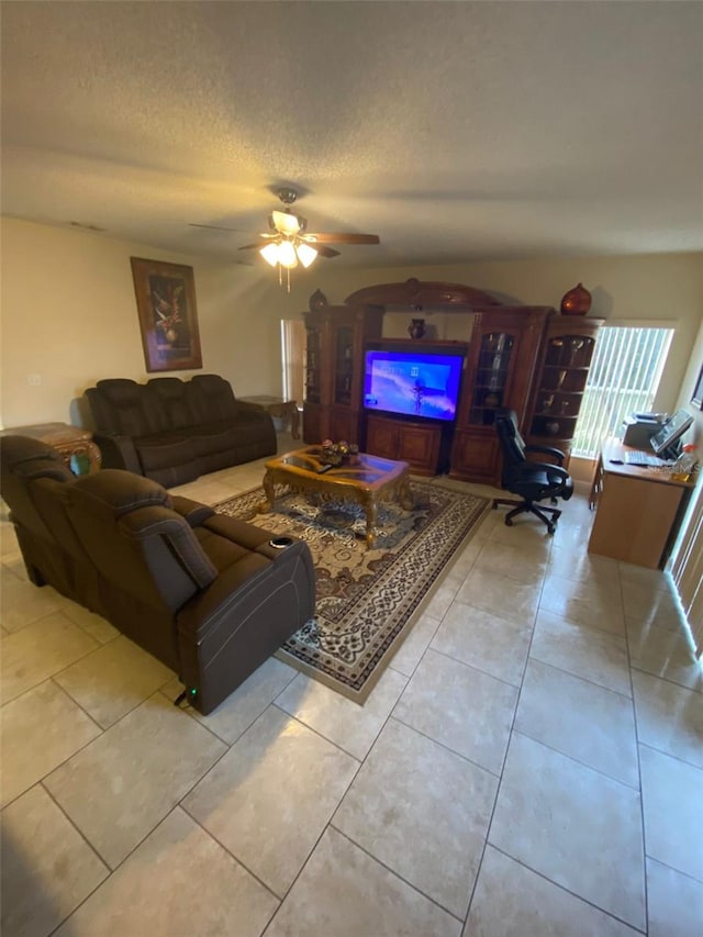 tiled living room with a textured ceiling and ceiling fan