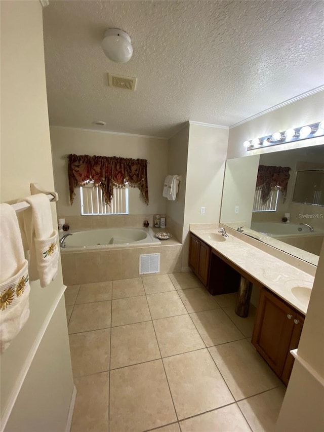 bathroom with tile patterned floors, tiled bath, vanity, and a textured ceiling