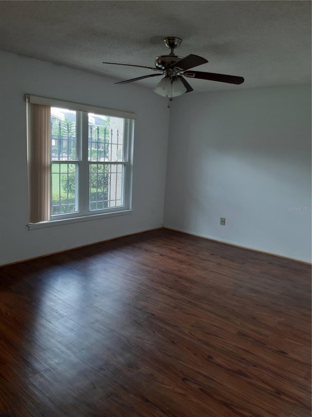 unfurnished room featuring a textured ceiling, ceiling fan, and dark wood-type flooring