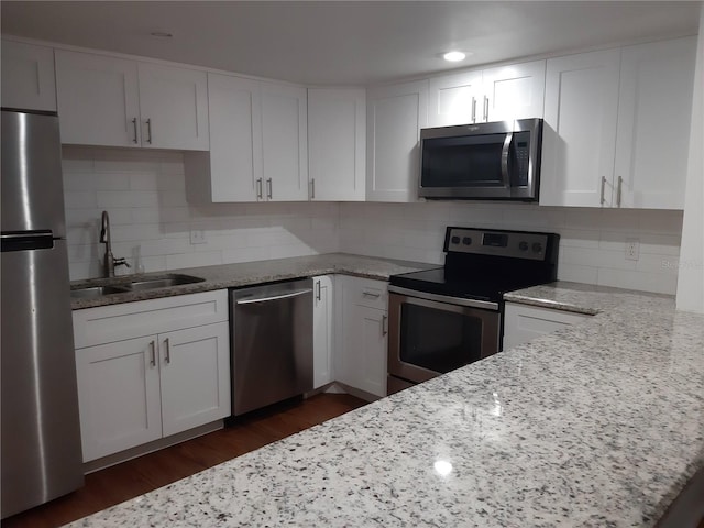 kitchen featuring light stone countertops, sink, stainless steel appliances, dark hardwood / wood-style floors, and white cabinets