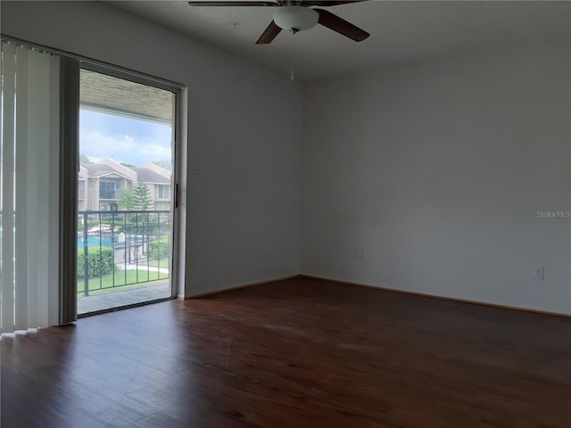 empty room with ceiling fan and dark wood-type flooring