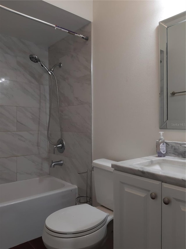 full bathroom with vanity, tiled shower / bath combo, and toilet