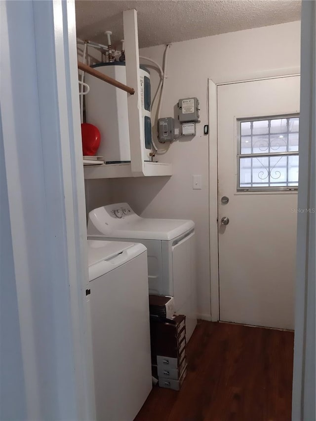 clothes washing area with independent washer and dryer, a textured ceiling, and dark hardwood / wood-style floors