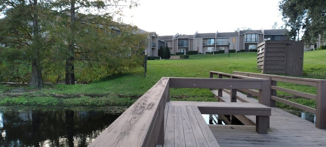 dock area with a water view and a lawn