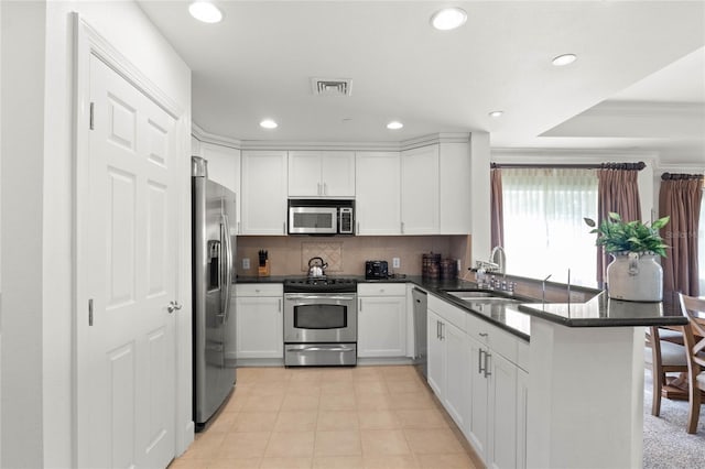 kitchen with white cabinetry, sink, stainless steel appliances, crown molding, and decorative backsplash