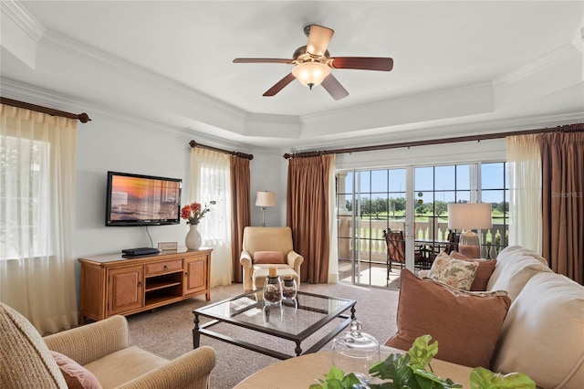 living room featuring a tray ceiling, ceiling fan, and ornamental molding