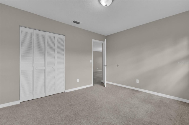 unfurnished bedroom featuring carpet flooring and a closet