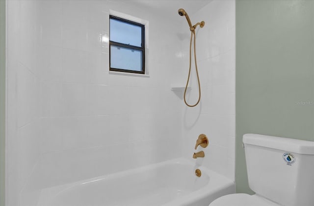 bathroom with tiled shower / bath combo and toilet