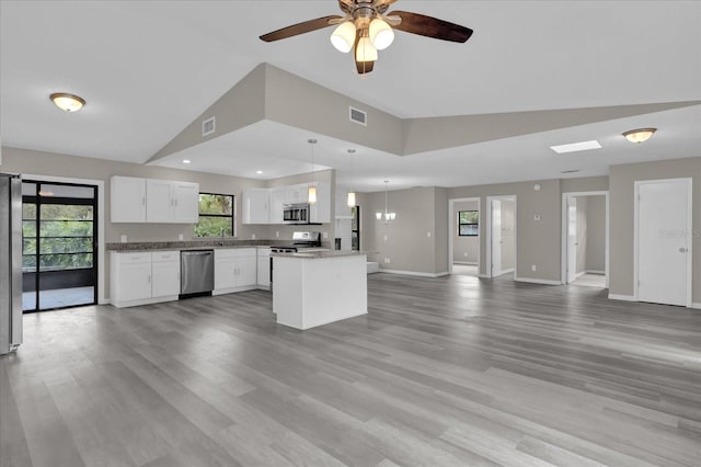 kitchen with stainless steel appliances, wood-type flooring, white cabinets, a center island, and hanging light fixtures