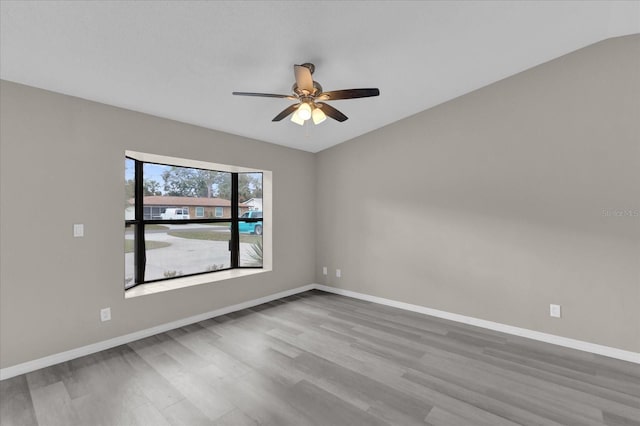 spare room featuring hardwood / wood-style flooring, ceiling fan, and lofted ceiling