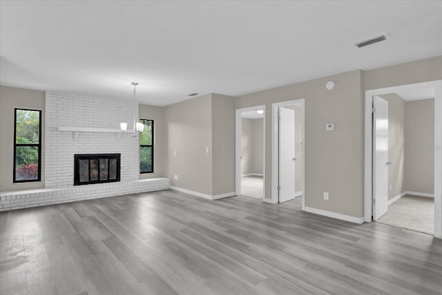 unfurnished living room with a fireplace and light hardwood / wood-style floors