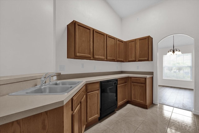 kitchen with sink, hanging light fixtures, dishwasher, a notable chandelier, and a towering ceiling