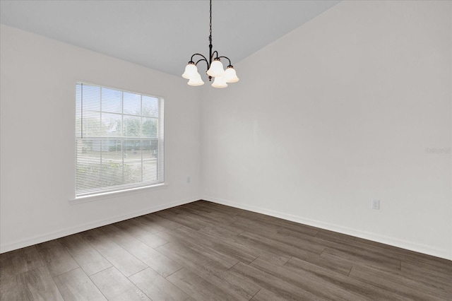 unfurnished room with dark wood-type flooring and an inviting chandelier