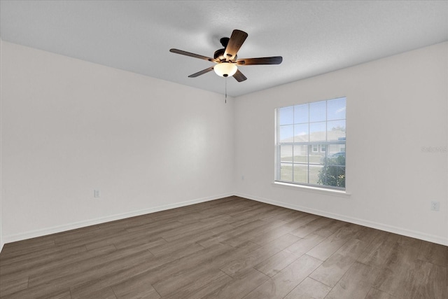 empty room featuring dark wood-type flooring and ceiling fan