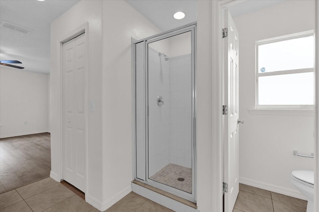 bathroom featuring a shower with door, tile patterned floors, ceiling fan, and toilet