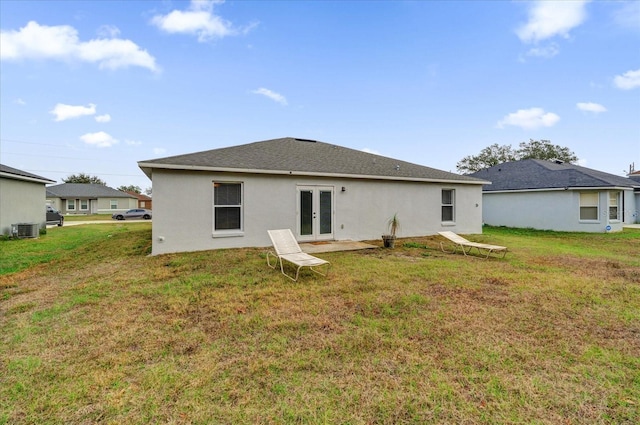 back of house featuring french doors, a lawn, and central air condition unit