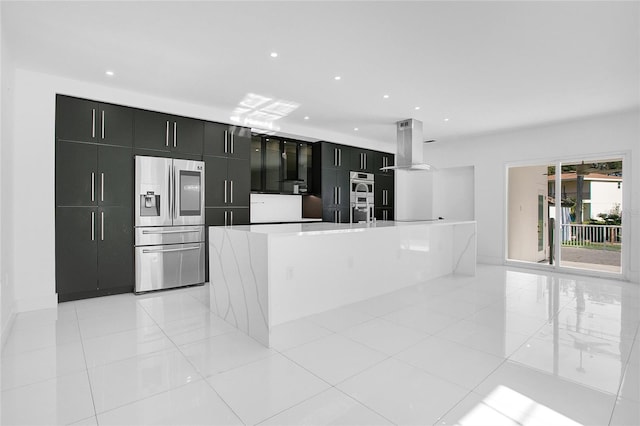 kitchen with island exhaust hood, appliances with stainless steel finishes, light tile patterned flooring, and an island with sink