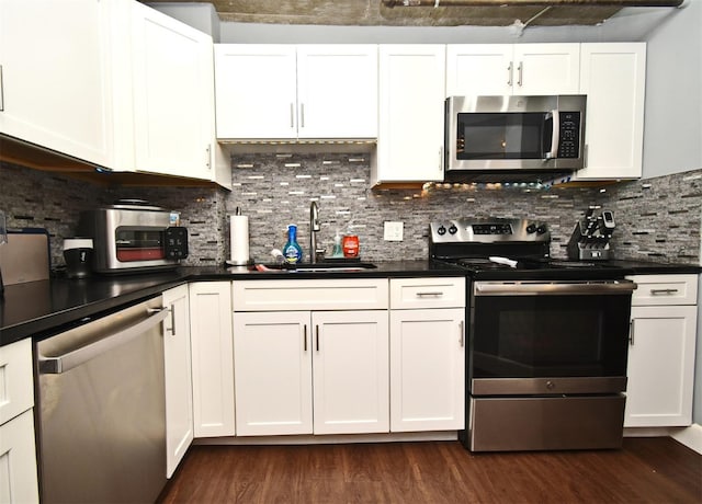 kitchen featuring appliances with stainless steel finishes, tasteful backsplash, and white cabinetry