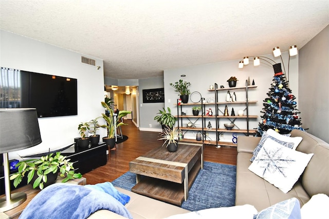 living room featuring dark wood-type flooring and a textured ceiling