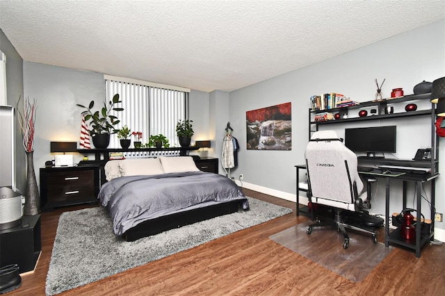 bedroom with a textured ceiling and dark wood-type flooring