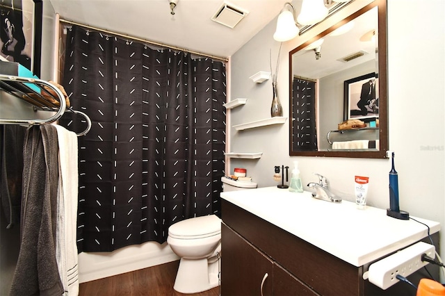 full bathroom with hardwood / wood-style flooring, vanity, shower / bath combination with curtain, and toilet