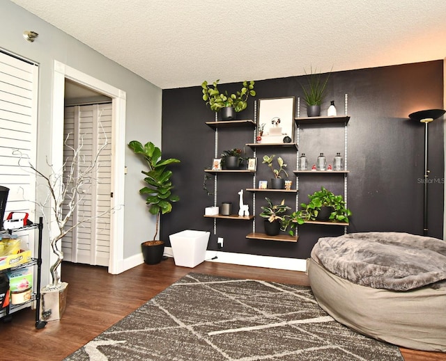 sitting room with dark hardwood / wood-style flooring and a textured ceiling