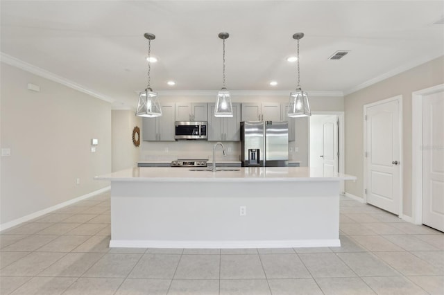 kitchen with pendant lighting, stainless steel appliances, a center island with sink, and sink