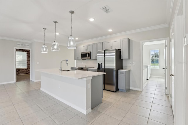 kitchen featuring sink, stainless steel appliances, an island with sink, gray cabinets, and ornamental molding