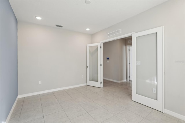 unfurnished bedroom with french doors and light tile patterned floors