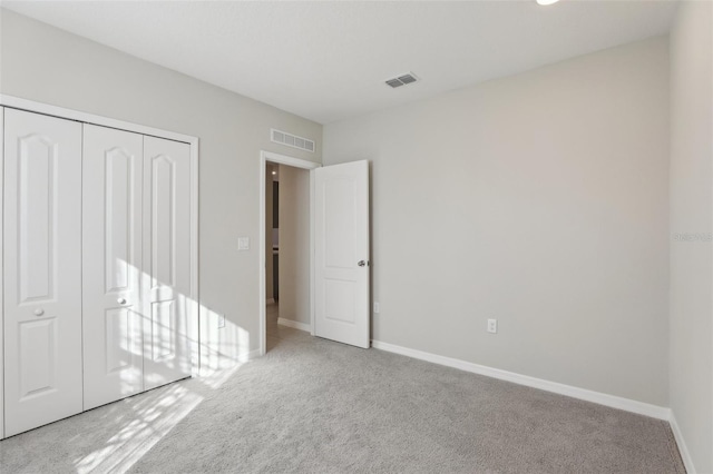 unfurnished bedroom with light carpet and a closet