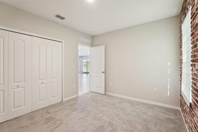 unfurnished bedroom with light carpet and a closet