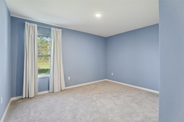 unfurnished room featuring light carpet